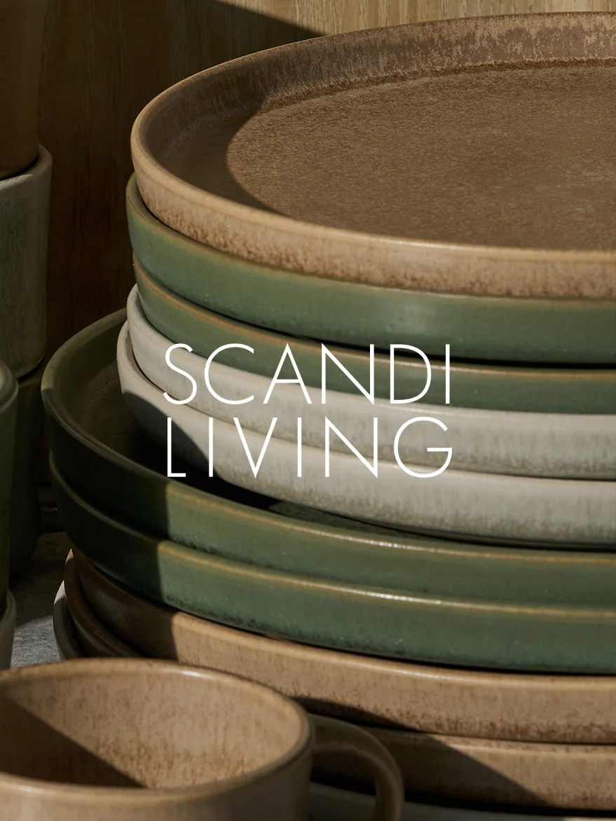 Piatti in ceramica impilati in toni terrosi con tazza, con testo 'SCANDI LIVING'.
