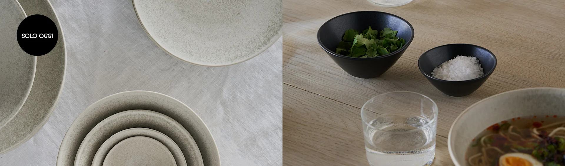 Piatti in ceramica impilati su tovaglia di lino con logo Solo Oggi, e ciotole con condimenti e ramen su tavolo di legno.