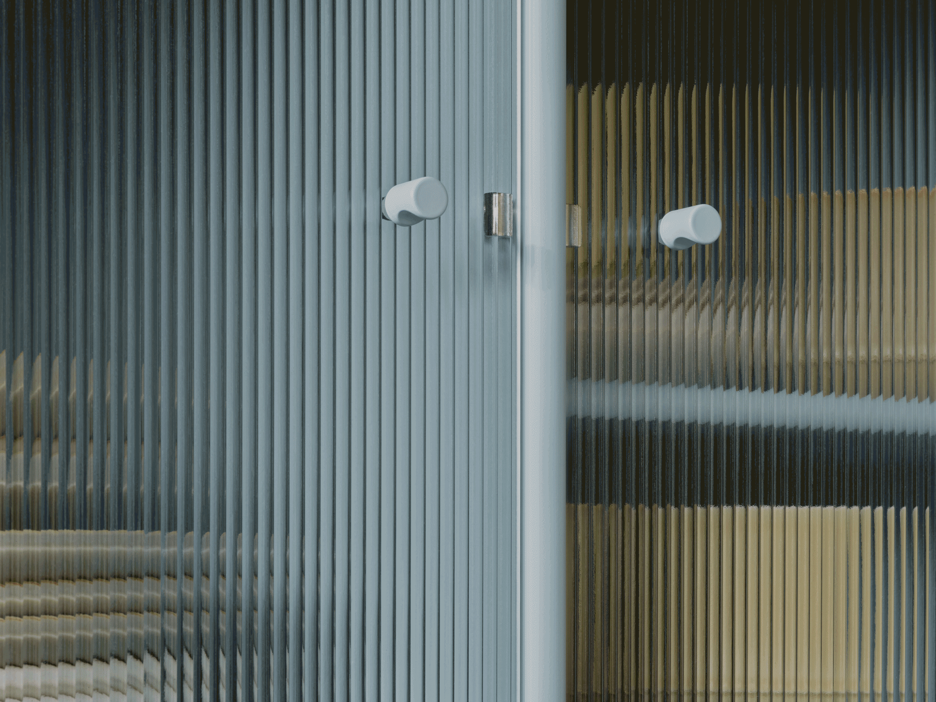 Primo piano di porta in vetro scanalato con due maniglie rotonde chiare, mostra colori distorti attraverso la trama traslucida.