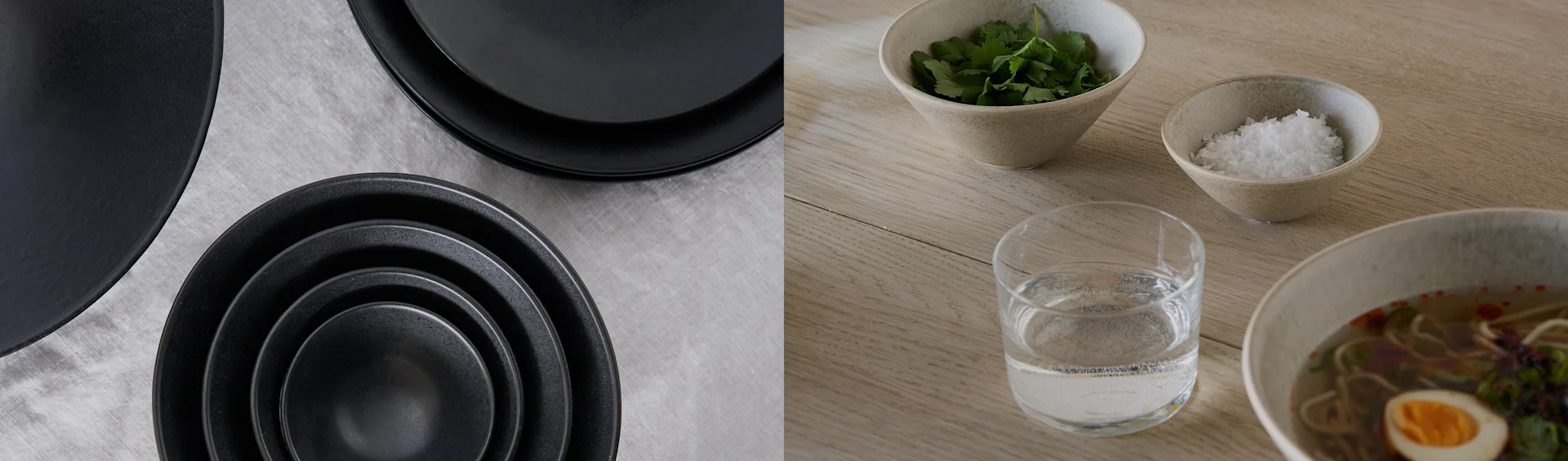 Piatti e ciotole neri su tessuto grigio; ciotola di ramen con uovo, coriandolo, sale e acqua su un tavolo di legno.