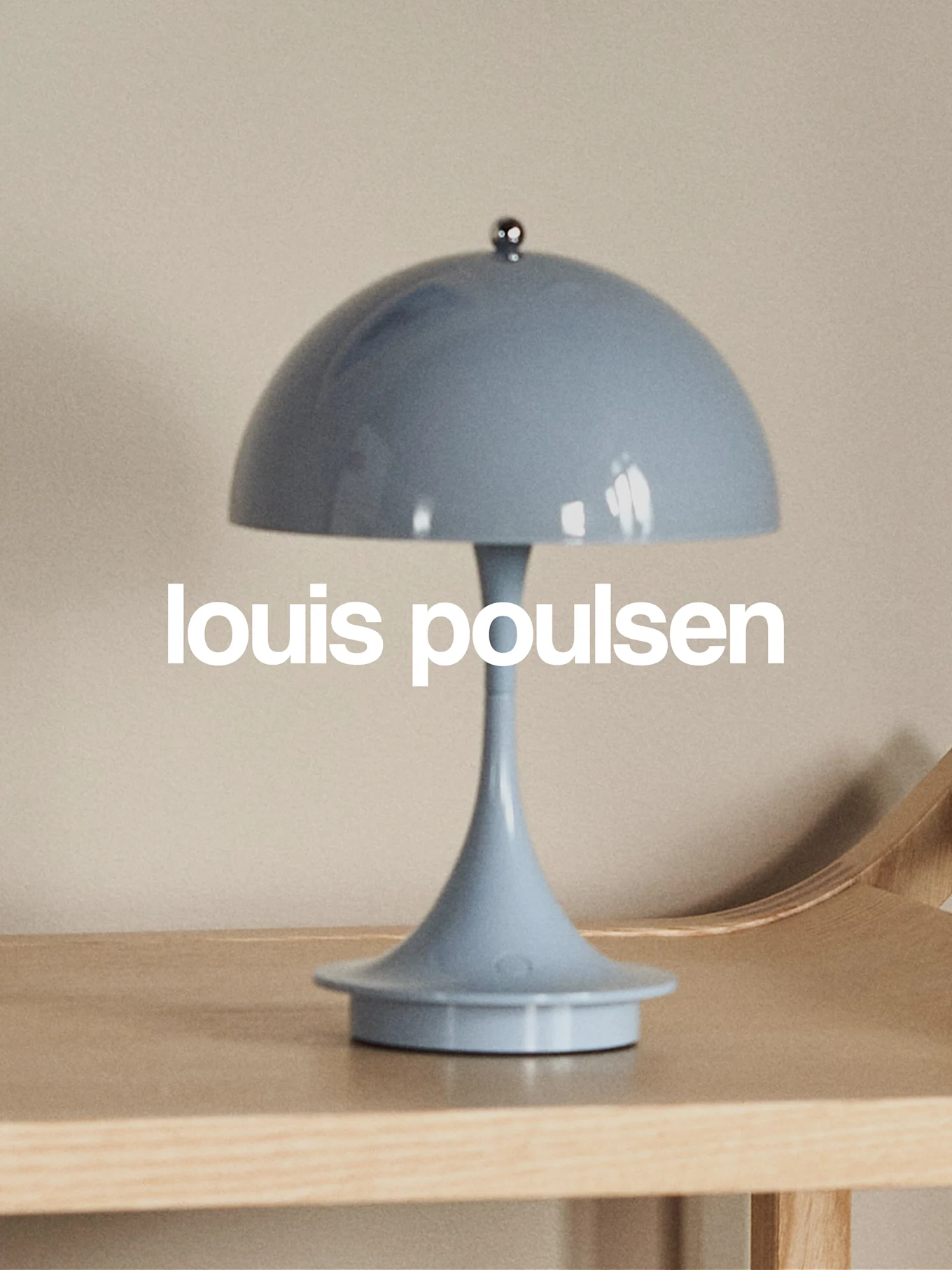 Lampada da tavolo a forma di fungo azzurra su una superficie di legno con il testo 'louis poulsen'.